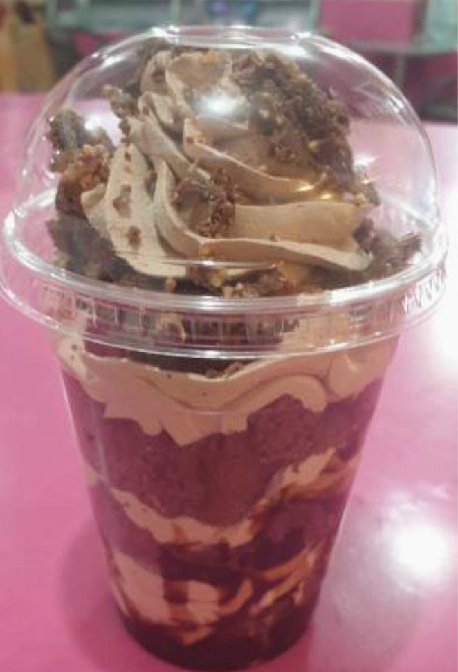 Strawberry cake cup topped with pistachio, Belgian chocolate and white chocolate sauce from Desi Cakes & Shakes Oldham
